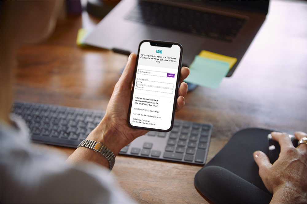 Mujer mirando el teléfono móvil para leer las preguntas frecuentes sobre el sistema de MCG Eversense.